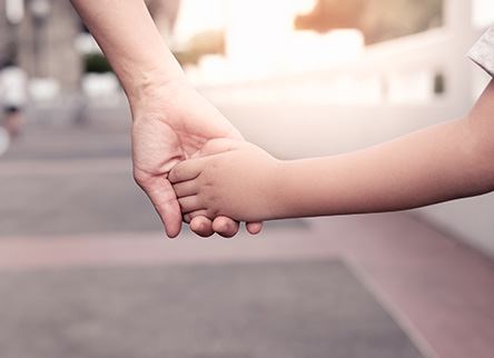 child and parent holding hands